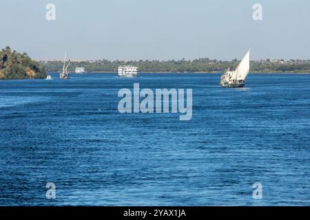 Erleben Sie das Beste aus beiden Welten auf einer Bootstour auf dem Nil. Erkunden Sie antike Tempel, entspannen Sie sich auf dem Sonnendeck und genießen Sie die atemberaubende Schönheit des Nils. Stockfoto