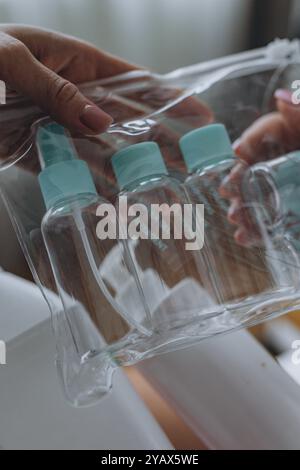 Der Kosmetiker zeigt dem Kunden ein Kosmetikprodukt und eine Reiseflasche. Hochwertige Fotos Stockfoto