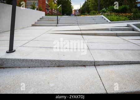 Gefliester Fußgängerweg mit Stufen in der städtischen Umgebung. Stockfoto