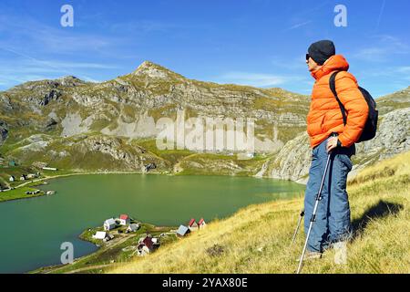 Ein Wanderer genießt den Blick auf den Kapetanovo See und die Berge. Ein Mann mit Wanderstöcken und einem Rucksack während einer Reise zu wunderschönen Orten in Montenegro Stockfoto