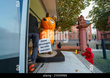 16. Oktober 2024, Rheinland-Pfalz, Mainz: Die Figur der Maus aus der Sendung mit der Maus wird vor dem landtag von Rheinland-Pfalz aus einem Fahrzeug entladen. Aktivistinnen und Aktivistinnen des „Campact e.V.“ sind mit der entführten „Maus“ vor dem ZDF und dem landtag in der Landeshauptstadt erschienen. Die Aktivisten wollen die Aufmerksamkeit auf den Wert des öffentlich-rechtlichen Rundfunks lenken. Seit Jahren schmückte eine Skulptur der Kultfigur aus der Sendung mit der Maus das vierteilige Gebäude des Westdeutschen Rundfunks (WDR) in der Kölner Innenstadt und begrüßte die Besucher. Foto: Andreas Arno Stockfoto