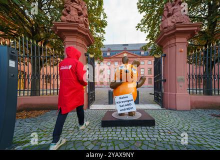 16. Oktober 2024, Rheinland-Pfalz, Mainz: Die Figur der Maus aus der Sendung mit der Maus steht mit Aktivisten der Kampagne vor dem Rheinland-pfälzischen landtag. Aktivistinnen und Aktivistinnen des „Campact e.V.“ sind mit der entführten „Maus“ vor dem ZDF und dem landtag in der Landeshauptstadt erschienen. Die Aktivisten wollen die Aufmerksamkeit auf den Wert des öffentlich-rechtlichen Rundfunks lenken. Seit Jahren schmückte eine Skulptur der Kultfigur aus der Sendung mit der Maus das vierteilige Gebäude des Westdeutschen Rundfunks (WDR) in der Kölner Innenstadt und begrüßte die Besucher. Foto: Andreas A Stockfoto