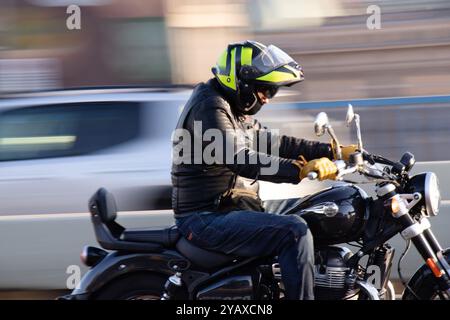 Belgrad, Serbien - 10. Oktober 2024: Motorradfahrer, der an einem sonnigen Tag auf einem Motorrad rasant fährt, Nahaufnahme Stockfoto