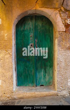 Grüne Tür, Blick auf eine alte Tür mit abblätternder grüner Farbe in der venezianischen Altstadt von Chania (Hania), Kreta, Griechenland Stockfoto
