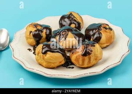 Teller mit Schokoladen-Profiterolen, Nahaufnahme Stockfoto