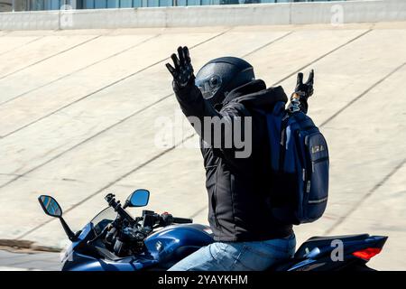 Mann, der ein Rennmotorrad fährt, ohne Hände auf der Autobahn. Stockfoto
