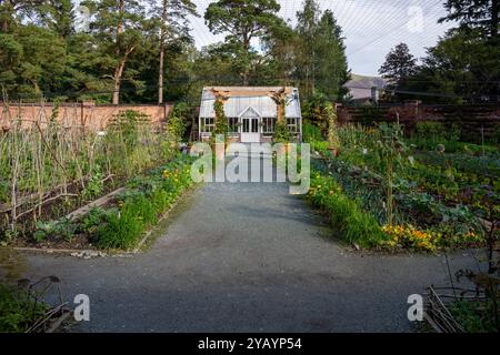 Ein schöner, formeller, ummauerter Garten mit viktorianischem Gewächshaus und Gemüseflecken in einem englischen Landgarten Stockfoto