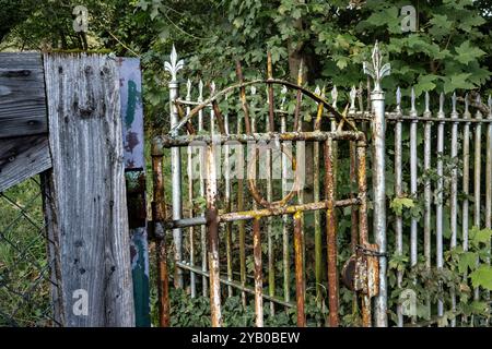 Alter Gartenzaun mit einem rostigen Gartentor Stockfoto