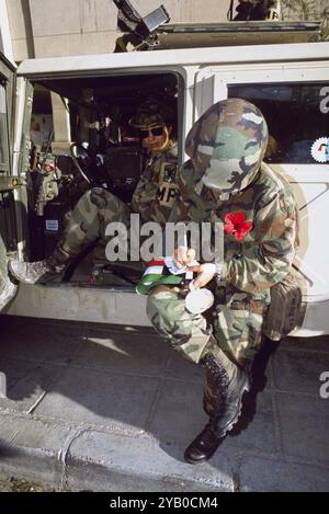 Erster Golfkrieg: 8. März 1991 amerikanische Militärpolizei vor dem Kuwait International Hotel in Kuwait City. Der Soldat mit der roten Blume schreibt eine Nachricht als Souvenir für einige Kinder. Stockfoto