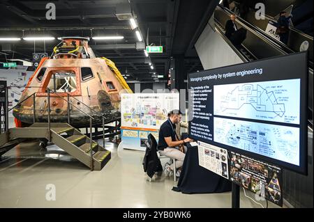 Die Menschen arbeiten neben einem Modell des Apollo 11 Command Module Columbia, das am 16. Oktober 2024 auf dem 75. Internationalen Astronautischen Kongress und der Ausstellung IAC 2024 in Mailand, Italien, ausgestellt wurde. Die IAC ist die jährliche und wichtigste Veranstaltung im Raumfahrtsektor mit mehr als 6000 Teilnehmern pro Jahr. Quelle: Piero Cruciatti/Alamy Live News Stockfoto