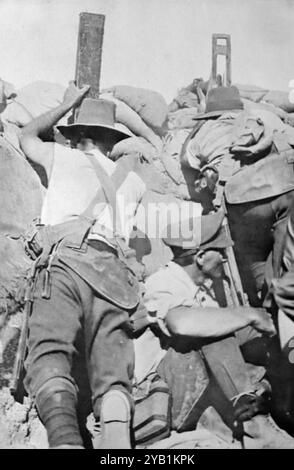 In einem australischen Graben mit einem Soldaten, der mit einem Periskop-Gewehr zielt, während ein anderer mit einem Periskop Wache hält. Eine dritte Figur sitzt zwischen den beiden. Aus einer Auswahl gedruckter Fotografien, die erstmals 1916 veröffentlicht wurden. Der Gallipoli-Feldzug begann während des Ersten Weltkriegs am 19. Februar 1915 und dauerte bis zum 9. Januar 1916. Dies wird manchmal als Dardanellen-Feldzug, Schlacht von Gallipoli und Verteidigung von Gallipoli bezeichnet. Stockfoto