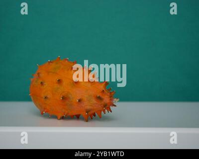 Kiwano Cucumis Metulifer tropische Frucht aus nächster Nähe auf dunkelgrünem Hintergrund. Stockfoto