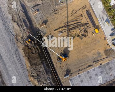 Bauarbeiten an der Küste. Schwere Maschinen arbeiten, um das Fundament vor Wasser und Sturmwellen zu stärken. Blick von der Drohne. Stockfoto