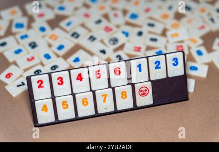 Klassisches Brettspiel von Rummikub, Spielsteine mit Zahlen in der Reihenfolge, Fokus auf Joker-Spielstein Stockfoto