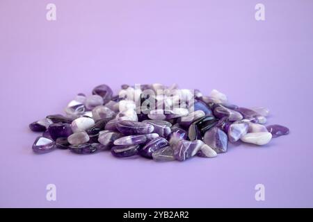 Set aus verschiedenen natürlichen Amethyst-Mineralsteinen und Edelsteinen auf violettem Hintergrund, teilweise fokussiert von oben Stockfoto