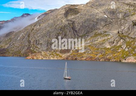 Prince Christian Sound, Grönland - 29. August 2024: Kleine Yacht, die einen der Fjorde im Prince Christian Sound in Südgrönland hinaufsegelt Stockfoto