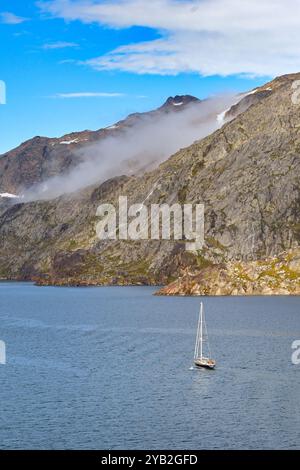 Prince Christian Sound, Grönland - 29. August 2024: Kleine Yacht, die einen der Fjorde im Prince Christian Sound in Südgrönland hinaufsegelt Stockfoto