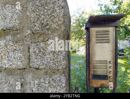 Verwitterte Gegensprechanlage an Steinmauer im Freien Stockfoto