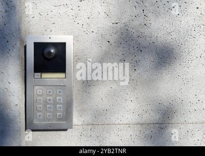 Gegensprechanlage aus Metall mit Tastatur an Betonwand Stockfoto