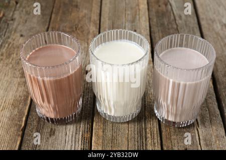 Verschiedene leckere Proteincocktails in Gläsern auf Holztisch Stockfoto