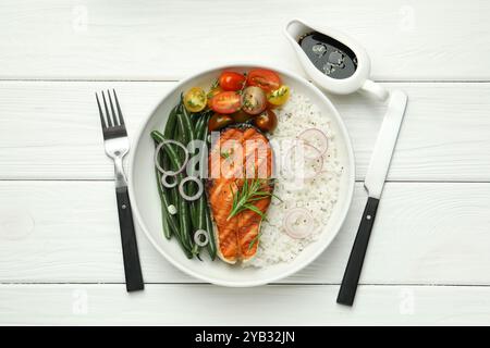 Leckeres gegrilltes Lachssteak mit Reis und Gemüse serviert mit Sojasauce auf weißem Holztisch, flach gelegt Stockfoto