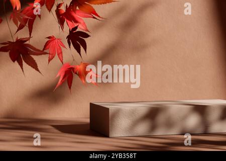 Natursteinpodium mit fallenden Herbstblättern vor beigem Hintergrund. Herbstsaison, Thanksgiving und saisonale Wohnkultur Szene. Premiummarke p Stockfoto