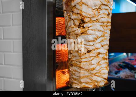 Saftiges Fleisch wird auf einem Shawarma-Spieß gebraten. Stockfoto