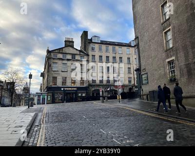 Blick auf Starbucks Coffee auf der High Street, Teil der Royal Mile, von der Cockburn Street. Edinburgh, Schottland, Vereinigtes Königreich. März 2024. Stockfoto