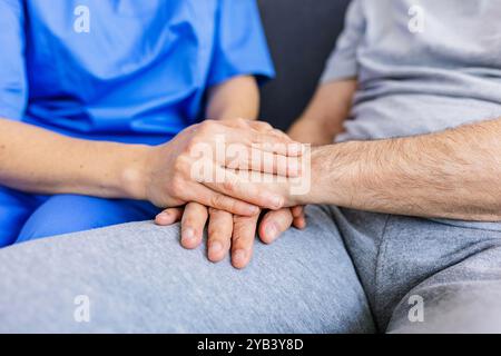Nahaufnahme einer Pflegekraft, die Hände mit einem älteren Patienten zu Hause hält Stockfoto