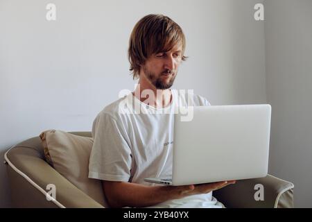 Porträt eines Mannes mit Bart, der an einem Laptop arbeitet Stockfoto