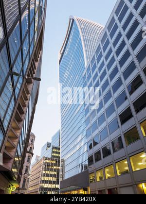 Flacher Blick auf moderne Bürogebäude und Wolkenkratzer in der City of London, beleuchtet in der Abenddämmerung Stockfoto