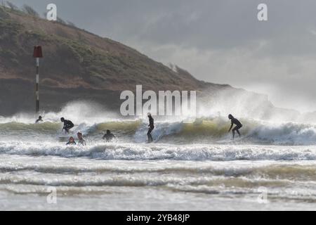 Surfer können Storm Brian optimal nutzen, indem sie in Salcombe, South Hams, Devon, die Wellen auf den North Sands ziehen und für die Herbsttemperaturen volle Weste tragen. Stockfoto