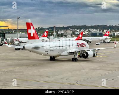 Flughafen Zürich, Swiss Airlines, Flugzeug, A320, Startvorbereitungen, Luftfahrt, Schweiz, Wetterfront, Wolken, Stadt im Hintergrund, internationale Reisen, Business-Reisen, Tourismus, Luftverkehrskrise, steigende Kerosinpreise, Klimaschutz in der Luftfahrt, nachhaltiges Fliegen, Schweizer Präzision, Flughafenbetrieb, Europäische Fluggesellschaften, Mobilität, globale Vernetzung, Flugreiseverkehr, CO2-Kompensation, Passagierverkehr, Schweizer Tourismus. *** Flughafen Zürich, Swiss Airlines, Flugzeug, A320, Startvorbereitungen, Luftfahrt, Schweiz, Wetterfront, Wolken, Stadt im Hinterland Stockfoto