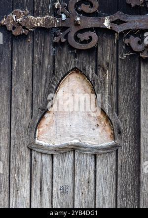 Alte Holztür mit blattförmigem Fensterrahmen Stockfoto