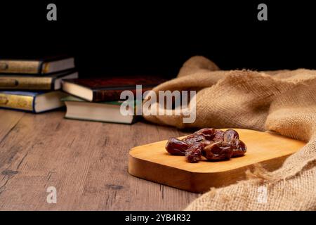 Viele Dattelpalmen stehen auf Schüsseln und Tassen Wasser und der Koran steht auf Holztischen, um auf die Zeit des Iftar zu warten, mit dem Konzept der ramadan Muslime A Stockfoto