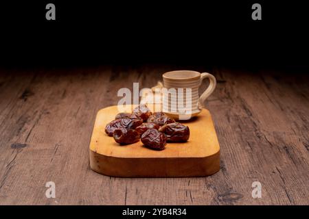 Viele Dattelpalmen stehen auf Schüsseln und Tassen Wasser und der Koran steht auf Holztischen, um auf die Zeit des Iftar zu warten, mit dem Konzept der ramadan Muslime A Stockfoto