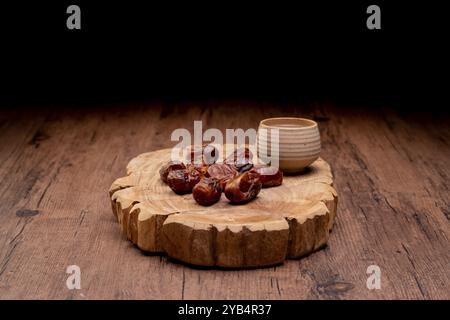 Viele Dattelpalmen stehen auf Schüsseln und Tassen Wasser und der Koran steht auf Holztischen, um auf die Zeit des Iftar zu warten, mit dem Konzept der ramadan Muslime A Stockfoto