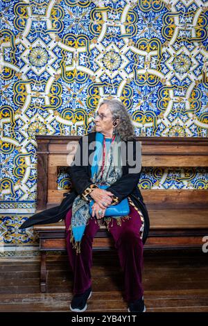 Ein reifer Reisende sitzt und bewundert Fliesen im Nationalmuseum (Museu Nacional do Azulejo) in Lissabon, Portugal Stockfoto