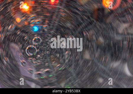 Dieses Makrofoto zeigt einen abstrakten Hintergrund mit Seifenblasen, die einen Wirbel von Farben reflektieren. Stockfoto