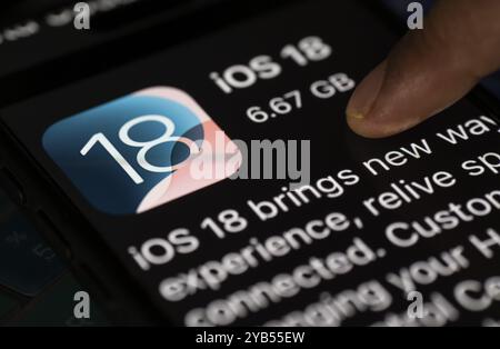 In dieser Abbildung installiert eine Person Updates von iOS 18 auf einem iPhone Stockfoto