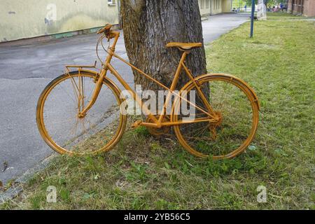 Gelbes Fahrrad auf Baumstamm gelehnt, Dekoration, bemalt, Albgut, altes Lager, ehemaliges Militärgebiet, Biosphärengebiet, Müensingen, Schwäbische Alb, Baden-Wuer Stockfoto