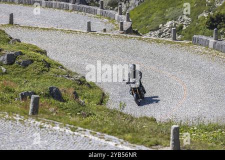 Motorradfahrer auf der Straße auf La Tremola, dem weltberühmten Alpenpass durch das Tremolo-Tal, mit 2 Personen das längste Straßenbaudenkmal der Schweiz Stockfoto