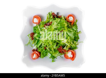 Frischer Salat mit Rucola, Lachs, Frischkäse und sonnengetrockneten Tomaten auf weißem Hintergrund Stockfoto