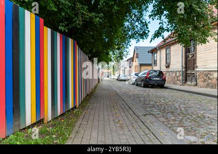 Tukums, Lettland - 22. August 2024: Farbenfroher Zaun entlang einer malerischen Harmonijas Straße in einer ruhigen Gegend tagsüber Stockfoto