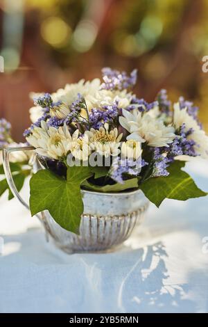 Tisch, Blumen und Vase bei Luxusveranstaltungen, Feiern oder Dekorationen im Freien im Hinterhof. Blumenpflanzen, Party und Blumenstrauß Nahaufnahme mit Blättern Stockfoto