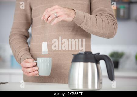Nahaufnahme eines älteren Mannes, der eine Tasse schwarzen Tee hält Stockfoto