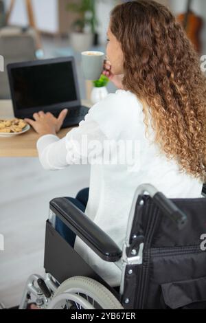 behinderte Frau im Rollstuhl mit laptop Stockfoto