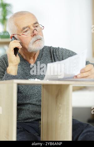 Glücklicher Geschäftsmann in Casualwear, der auf dem Smartphone spricht Stockfoto