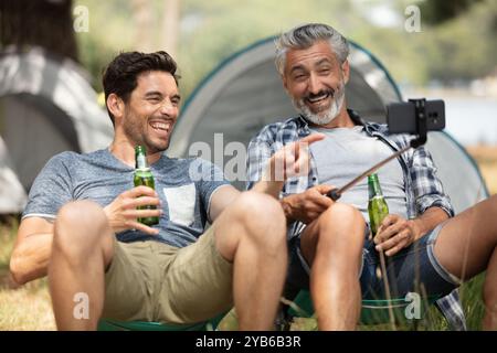 Zwei Männer auf Campingausflug trinken Bier und machen Selfie Stockfoto