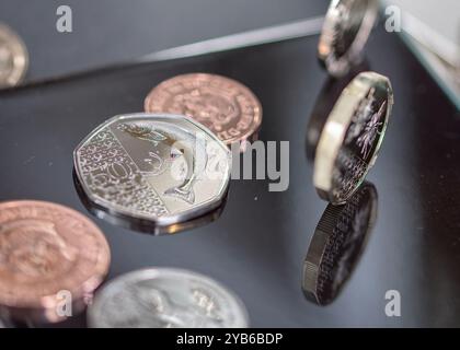 Sterling-Münzen, seine Königliche Hoheit König Karl III., stehend und liegend auf einem schwarzen reflektierenden Oberteil Stockfoto